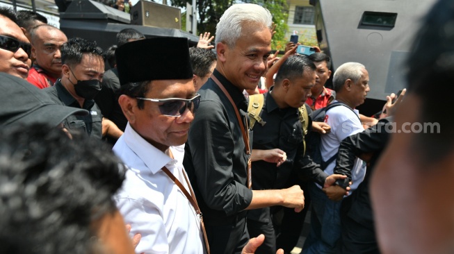 Bakal calon presiden dari PDI Perjuangan Ganjar Pranowo (kanan) dan bakal calon wakil presiden Mahfud MD (kiri) jalan menuju KPU dari Tugu Proklmasi di Jakarta, Kamis (19/10/2023). [ANTARA FOTO/Indrianto Eko Suwarso/Spt]