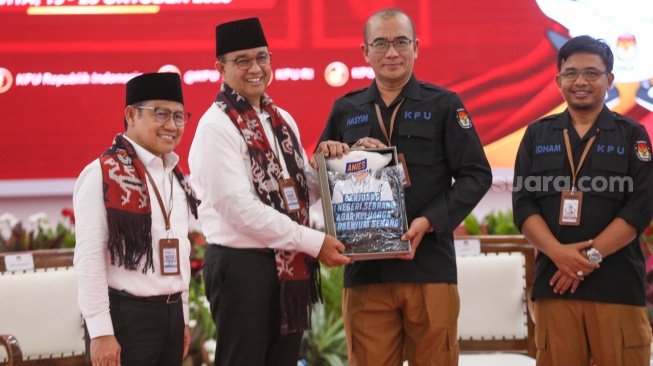 Bakal calon Presiden Anies Baswedan (kedua kiri) bersama bakal calon Wakil Presiden Muhaimin Iskandar (kiri) dan Ketua KPU Hasyim Asy'ari (kedua kanan) saat melakukan pendaftaran Calon Presiden dan Wakil Presiden Pemilihan Umum 2024 di Gedung KPU, Jakarta, Kamis (19/10/2023). [Suara.com/Alfian Winanto]