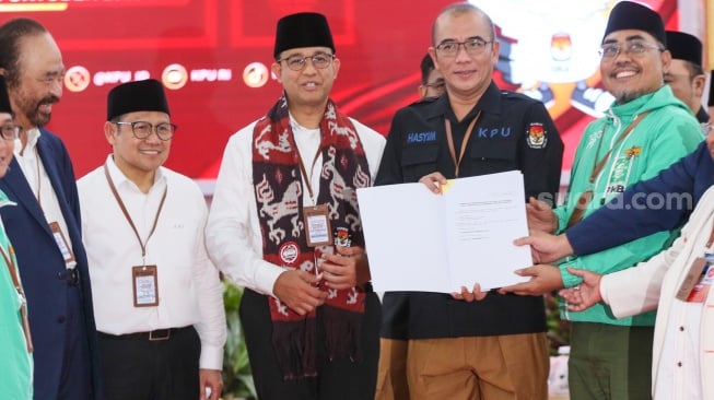 Bakal calon Presiden Anies Baswedan (tengah) bersama bakal calon Wakil Presiden Muhaimin Iskandar (kiri) dan Ketua KPU Hasyim Asy'ari (kanan) saat melakukan pendaftaran Calon Presiden dan Wakil Presiden Pemilihan Umum 2024 di Gedung KPU, Jakarta, Kamis (19/10/2023). [Suara.com/Alfian Winanto]