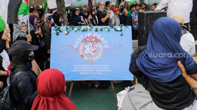 Massa aksi melakukan unjuk rasa di depan kantor perwakilan Perserikatan Bangsa-Bangsa (PBB) di Jakarta, Jumat (20/10/2023). [Suara.com/Alfian Winanto]