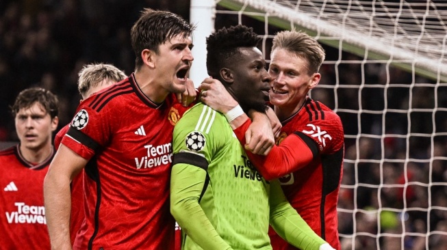 Kiper Manchester United, Andre Onana (kanan) merayakan bersama Harry Maguire dan rekan satu timnya setelah menyelamatkan tendangan penalti di akhir pertandingan ketiga Grup A Liga Champions 2023-2024 antara Manchester United vs Copenhagen di Old Trafford, di Manchester, utara- Inggris barat, pada 24 Oktober 2023.Paul ELLIS / AFP