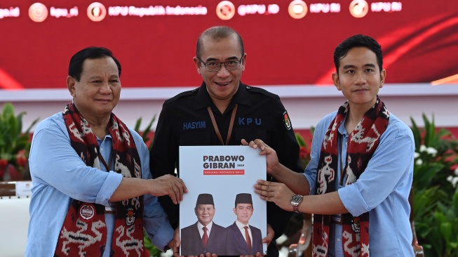 Ketua KPU Hasyim Asy'ari (tengah) menerima berkas pendaftaran pencalonan dari pasangan bakal calon presiden dan wakil presiden Prabowo Subianto (kiri) dan Gibran Rakabuming Raka (kanan) di Kantor KPU Pusat, Jakarta, Rabu (25/10/2023). [ANTARA FOTO/Sigid Kurniawan].