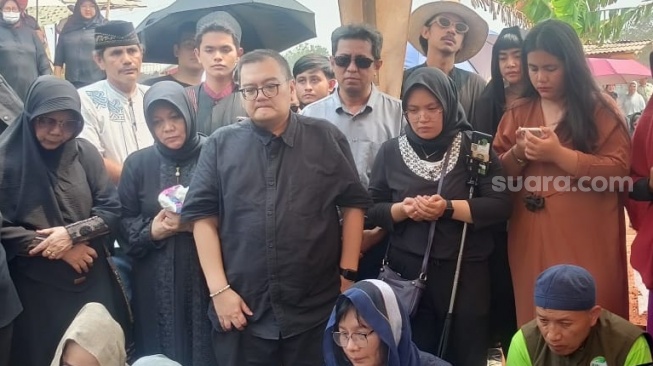 Calon suami Shena Malsiana, Arif (mengenakan kacamata dan kemeja hitam) ikut mengantar jenazah sang kekasih di TPU Bojong Nangka, Tangerang, Banten, Kamis (26/10/2023). [Rena Pangesti/Suara.com]