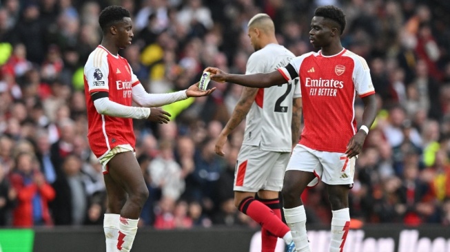 Gelandang Arsenal, Bukayo Saka (kanan) memberikan ban kapten kepada Eddie Nketiah (kiri) selama pertandingan Liga Inggris antara Arsenal dan juga Sheffield United di area Stadion Emirates di dalam London pada 28 Oktober 2023.Glyn KIRK / AFP.