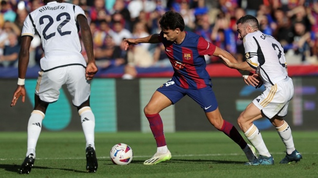 Penyerang Barcelona asal Portugal, Joao Felix (tengah) ditantang bek Real Madrid Spanyol Dani Carvajal selama pertandingan pekan ke-11 Liga Spanyol 2023-2024 antara FC Barcelona vs Real Madrid CF di Estadi Olimpic Lluis Companys di Barcelona pada 28 Oktober 2023.LLUIS GEN / AFP