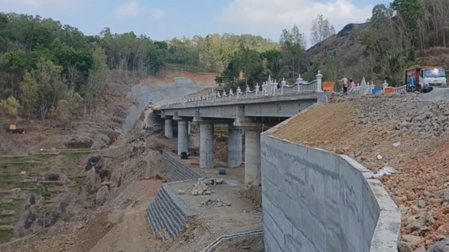 Pemandangan jembatan penghubung jalan tembus Gunungkidul-Sleman yang melintas di wisata air terjun Kedung kandang. [KakaTV/YouTube]