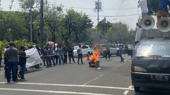 Puluhan mahasiswa Papua, yang tergabung dalam Front Mahasiswa Tolikara se-Indonesia memblokade Jalan Medan Merdeka Utara, tepatnya di Kantor Kementerian Dalam Negeri (Kemendagri). (Suara.com/Fakhri)