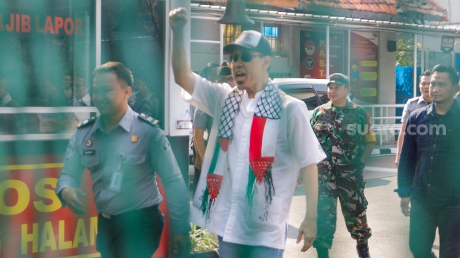 Mantan juru bicara Front Pembela Islam (FPI) Munarman (tengah) berjalan keluar usai bebas dari penjara di Rutan Salemba, Jakarta, Senin (30/10/2023). [Suara.com/Alfian Winanto]