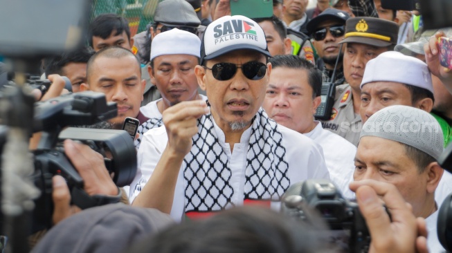 Mantan juru bicara Front Pembela Islam (FPI) Munarman (tengah) menemui pendukungnya usai bebas dari penjara di Rutan Salemba, Jakarta, Senin (30/10/2023). [Suara.com/Alfian Winanto]