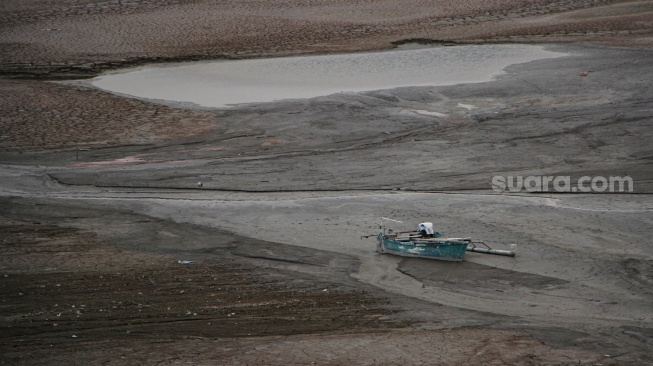 Perahu milik warga berada di area genangan Waduk Bili-Bili yang mengering di Kabupaten Gowa, Sulawesi Selatan, Minggu (29/10/2023). [ANTARA FOTO/Arnas Padda/nz]
