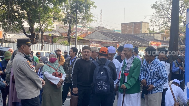 Sejumlah simpatisan  Persaudaraan Islam (FPI) menanti Munarman yang bebas murni di area depan gerbang Lembaga Pemasyarakatan (Lapas) Kelas II A Salemba, Jakarta Pusat, Senin (30/10/2023). (Suara.com/Faqih)