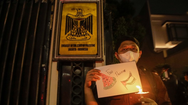 Sejumlah elemen masyarakat menyalakan lilin saat mengikuti aksi damai Bela Palestina di Kedutaan Besar Palestina, Jakarta, Kamis (2/11/2023). [Suara.com/Alfian Winanto]