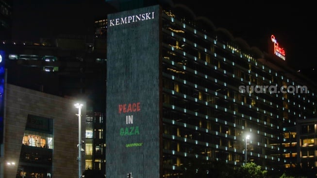 Video Mapping berisi pesan dukungan ditampilkan saat aksi solidaritas untuk Palestina di kawasan Bundaran HI, Jakarta, Jumat (3/11/2023). [Suara.com/Alfian Winanto]