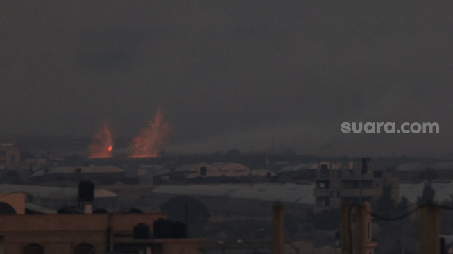 Kilatan cahaya terlihat menerangi langit selama serangan militer Israel di Rafah di Jalur Gaza, Palestina, Kamis (2/11/2023). [SAID KHATIB/AFP]