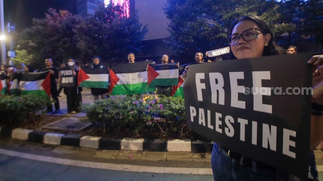 Sejumlah aktivis dari Greenpeace saat menggelar aksi solidaritas untuk Palestina di kawasan Bundaran HI, Jakarta, Jumat (3/11/2023). [Suara.com/Alfian Winanto]