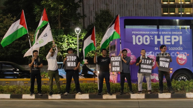 Sejumlah aktivis dari Greenpeace saat menggelar aksi solidaritas untuk Palestina di kawasan Bundaran HI, Jakarta, Jumat (3/11/2023). [Suara.com/Alfian Winanto]