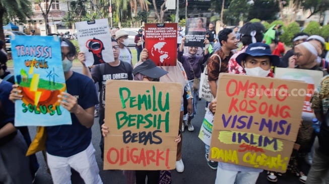 Sejumlah peserta membawa poster saat aksi krisis iklim di depan Kantor KPU, Jakarta, Jumat (3/11/2023). [Suara.com/Alfian Winanto]