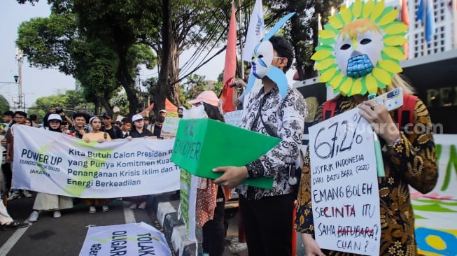 Sejumlah peserta membawa poster saat aksi krisis iklim di depan Kantor KPU, Jakarta, Jumat (3/11/2023). [Suara.com/Alfian Winanto]