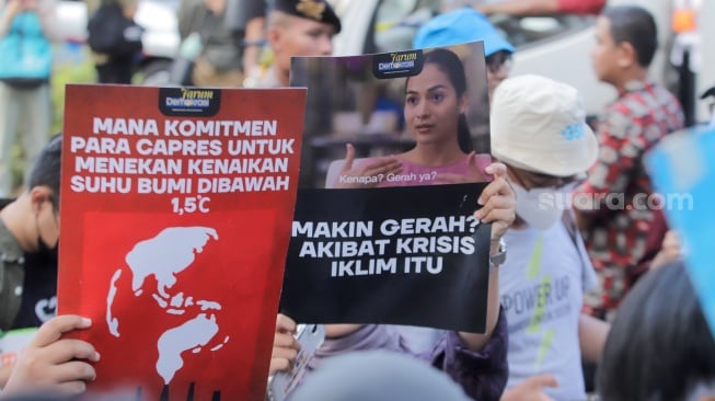 Sejumlah peserta membawa poster saat aksi krisis iklim di depan Kantor KPU, Jakarta, Jumat (3/11/2023). [Suara.com/Alfian Winanto]