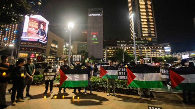 Sejumlah aktivis dari Greenpeace saat menggelar aksi solidaritas untuk Palestina di kawasan Bundaran HI, Jakarta, Jumat (3/11/2023). [Suara.com/Alfian Winanto]