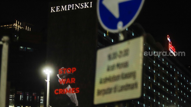 Video Mapping berisi pesan dukungan ditampilkan saat aksi solidaritas untuk Palestina di kawasan Bundaran HI, Jakarta, Jumat (3/11/2023). [Suara.com/Alfian Winanto]