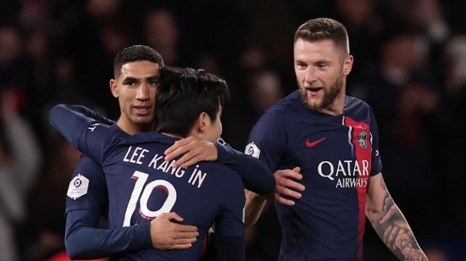 Paris Saint-Germain midfielder from South Korea, Lee Kang-in celebrates his team's first goal with Achraf Hakimi (left) and Milan Skriniar (right) during the 2023-2024 French Ligue 1 match between Paris Saint-Germain vs Montpellier Herault SC at the Parc des Stadium Princes in Paris on November 3, 2023.FRANCK FIFE / AFP.