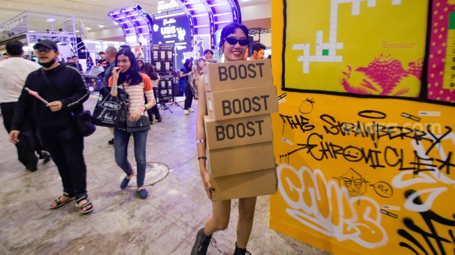 Pengunjung memilih barang dalam acara Urban Sneaker Society (USS) 2023 yang diselenggarakan di JCC Senayan, Jakarta, Minggu (5/11/2023). [Suara.com/Alfian Winanto]