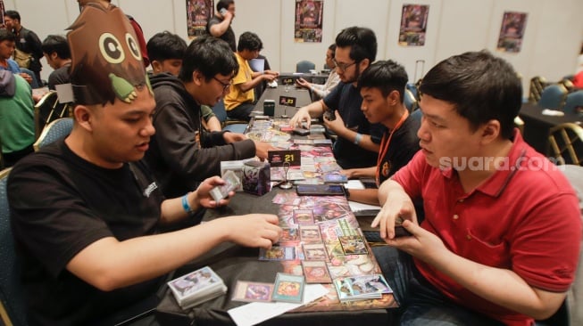 Pengunjung bermain Trading Card Game (TCG) di acara Indonesia Comic Con x DG Con 2023 di Jakarta Convention Center (JCC), Jakarta, Minggu (5/11/2023). [Suara.com/Alfian Winanto]