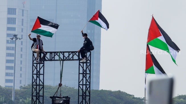 Massa saat mengikuti Aksi Damai Bela Palestina di Monas, Jakarta, Minggu (5/11/2023). [Suara.com/Alfian Winanto]