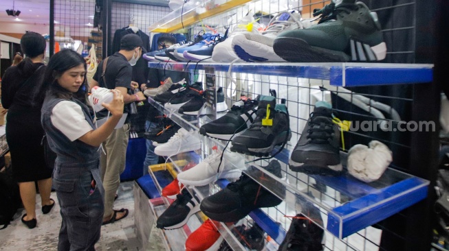 Pengunjung memilih barang dalam acara Urban Sneaker Society (USS) 2023 yang diselenggarakan di JCC Senayan, Jakarta, Minggu (5/11/2023). [Suara.com/Alfian Winanto]