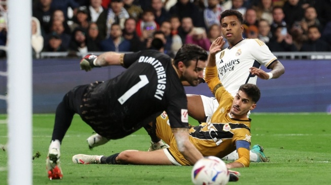 Real Madrid striker Rodrygo competes with Rayo Vallecano midfielder Oscar Valentin and goalkeeper Stole Dimitrievski during the match week 12 of the 2023-2024 Spanish League between Real Madrid vs Rayo Vallecano at the Santiago Bernabeu stadium in Madrid on November 5 2023.Pierre-Philippe MARCOU / AFP