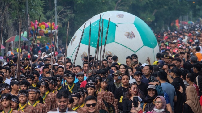 Peserta menggelindingkan bola besar menuju kompleks Pura Mangkunegaran saat kirab Trophy Experience FIFA U-17 World Cup di Solo, Jawa Tengah, Minggu (5/11/2023). Indonesia menjadi tuan rumah turnamen Piala Dunia U-17 yang akan berlangsung dari 10 November 2023 sampai 2 Desember 2023. (ANTARAFOTO/Maulana Surya).