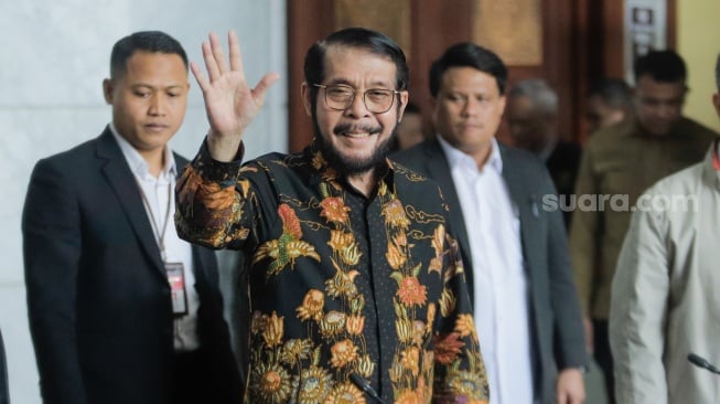 Mantan Ketua Mahkamah Konstitusi Anwar Usman menyapa awak media saat datang untuk memberikan keterangan pers di Gedung MK, Jakarta, Rabu (8/11/2023). [Suara.com/Alfian Winanto]