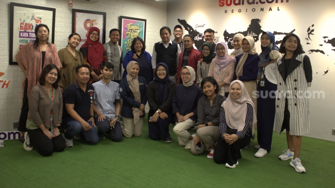 Pemred Suara.com, Suwarjono beserta tim redaksi berfoto bersama rombongan Humas UGM di kantor Suara.com, Jalan Kuningan Timur, Jakarta Selatan, Rabu (8/11/2023). [Suara.com/Dani]