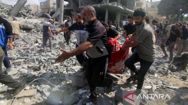 Arsip - Sejumlah warga mengangkut para korban dari sebuah gedung yang hancur akibat serangan Israel di Kota Rafah di Jalur Gaza bagian selatan, Selasa (17/10/2023). (ANTARA/Xinhua/Khaled Omar/tm/am.)