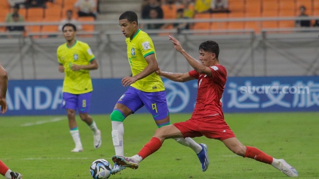 Pesepak bola Timnas Iran U-17 Barajeh Yaghoob berusaha merebut bola dari pemain Timnas Brasil U-17 Kaua Elias pada pertandingan Grup C Piala Dunia U-17 2023 di Jakarta International Stadium (JIS), Jakarta, Sabtu (11/11/2023). [Suara.com/Alfian Winanto]