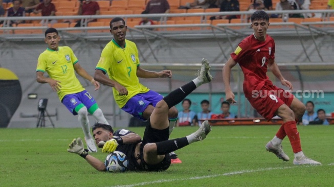 Kiper Timnas Iran U-17 Shakouri Arsha berhasil mengamankan bola dari tendangan Timnas Brasil U-17 pada pertandingan Grup C Piala Dunia U-17 2023 di Jakarta International Stadium (JIS), Jakarta, Sabtu (11/11/2023). [Suara.com/Alfian Winanto]