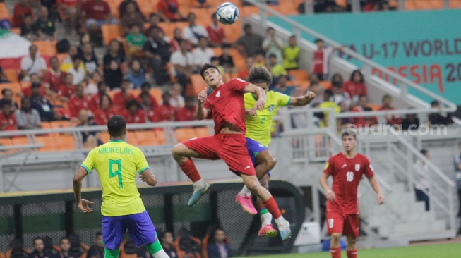 Pesepak bola Timnas Iran U-17 berebut bola atas dengan pemain Timnas Brasil U-17 pada pertandingan Grup C Piala Dunia U-17 2023 di Jakarta International Stadium (JIS), Jakarta, Sabtu (11/11/2023). [Suara.com/Alfian Winanto]