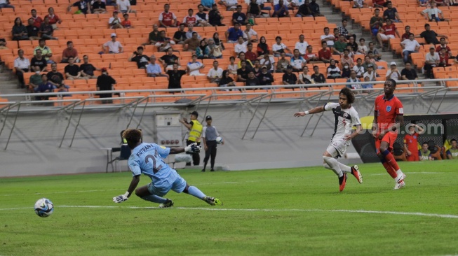 Pesepak bola Timnas Inggris U-17 Oboavwoduo Justin saat mencetak gol melewati kiper Timnas Kaledonia Baru U-17 Kutran Nicolas pada pertandingan Grup C Piala Dunia U-17 di Jakarta International Stadium (JIS), Jakarta, Sabtu (11/11/2023). [Suara.com/Alfian Winanto]