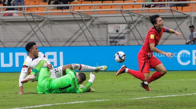 Pesepak bola Timnas Korea Selatan U-17 Kim Myeongjun gagal melewati kiper Timnas Amerika Serikat U-17 Beaudry Adam untuk mencetak gol pada pertandingan Grup E Piala Dunia U-17 2023 di Jakarta International Stadium (JIS), Jakarta, Minggu (12/11/2023). [Suara.com/Alfian Winanto]
