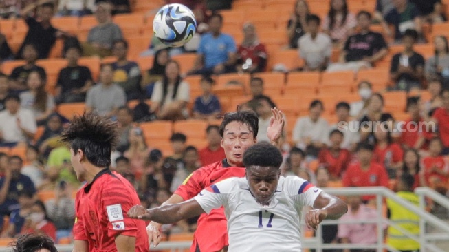 Pesepak bola Timnas Korea Selatan U-17 Seo Jeonghyeok berebut bola atas dengan pemain Timnas Amerika Serikat U-17 Figueora Keyrol pada pertandingan Grup E Piala Dunia U-17 2023 di Jakarta International Stadium (JIS), Jakarta, Minggu (12/11/2023). [Suara.com/Alfian Winanto]
