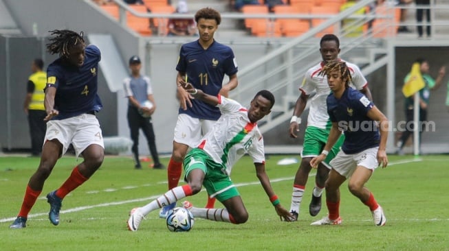 Pesepak bola Timnas Burkina Faso U-17 Alio Souleymane berusahan melewati pemain Timnas Prancis U-17 pada pertandingan Grup E Piala Dunia U-17 2023 di Jakarta International Stadium (JIS), Jakarta, Minggu (12/11/2023). [Suara.com/Alfian Winanto]