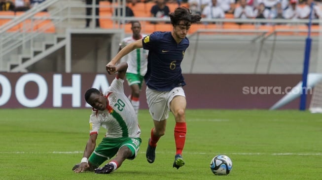 Pesepak bola Timnas Prancis U-17 Ferro Nolan berhasil merebut bola dari pemain Timnas Burkina Faso U-17 Ouedraogo Emmanuel pada pertandingan Grup E Piala Dunia U-17 2023 di Jakarta International Stadium (JIS), Jakarta, Minggu (12/11/2023). [Suara.com/Alfian Winanto]