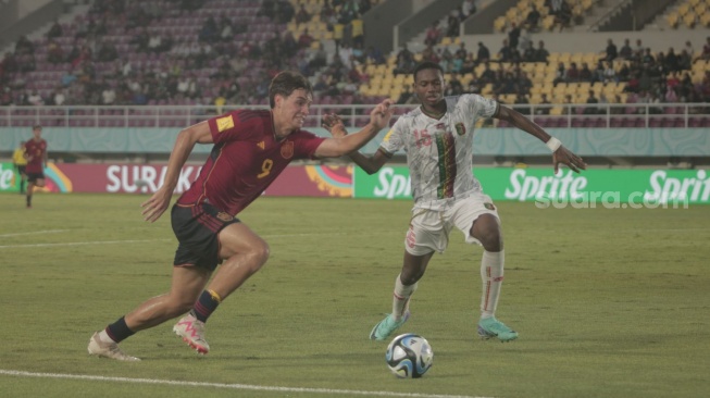 Striker Timnas Spanyol U-17, Marc Guiu (kiri) berusaha melewati bek Mali, Baye Coulibaly dalam matchday kedua Grup B Piala Dunia U-17 2023 di Stadion Manahan, Solo, Senin (13/11/2023). [Suara.com/Ronald Seger Prabowo]