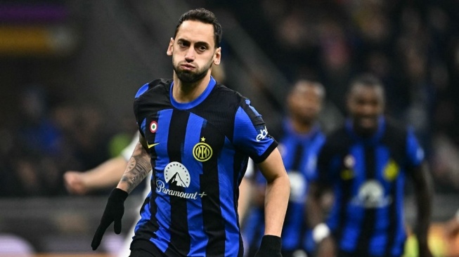 Gelandang Inter Milan, Hakan Calhanoglu melakukan selebrasi setelah mencetak gol kedua timnya lewat titik putih selama pertandingan pekan ke-12 Liga Italia 2023-2024 antara Inter Milan vs Frosinone di Stadion San Siro, di Milan pada 12 November 2023.GABRIEL BOUYS / AFP.