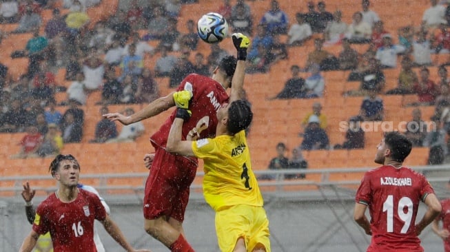 Penjaga Gawang Timnas Iran U-17 Shakouri Arsha menghalau umpan pemain Timnas Inggris U-17 pada pertandingan Grup C Piala Dunia U-17 2023 di Jakarta International Stadium (JIS), Jakarta, Selasa (14/11/2023). [Suara.com/Alfian Winanto]