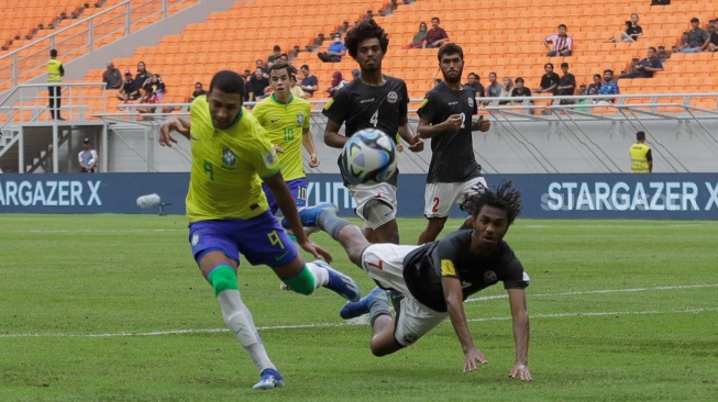 Pesepak bola Timnas Brasil U-17 Kaua Elias berebut bola pemain Timnas Kaledonia Baru U-17 Gohoupe Bayron pada pertandingan Grup C Piala Dunia U-17 2023 di Jakarta International Stadium (JIS), Jakarta, Selasa (14/11/2023). [Suara.com/Alfian Winanto]