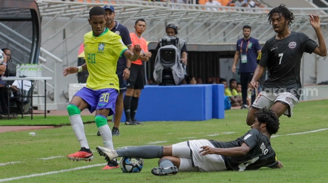 Pesepak bola Timnas Brasil U-17 Estevao berusaha menghindari tackel pemian Timnas Kaledonia Baru U-17 Diko Gregory pada pertandingan Grup C Piala Dunia U-17 2023 di Jakarta International Stadium (JIS), Jakarta, Selasa (14/11/2023). [Suara.com/Alfian Winanto]