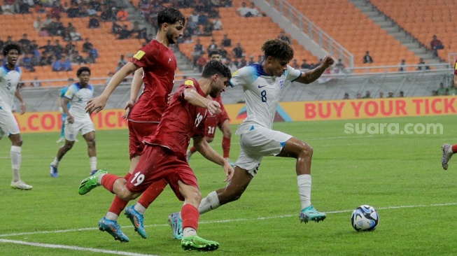 Pesepak bola Timnas Inggris U-17 Golding Michael berusah melewati Pemain Timnas Iran U-17 pada pertandingan Grup C Piala Dunia U-17 2023 di Jakarta International Stadium (JIS), Jakarta, Selasa (14/11/2023). [Suara.com/Alfian Winanto]