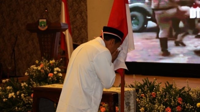 Salah satu mantan teroris yang dulu tergabung dalam JI dan JAD mencium bendera merah putih. [Bantennews.co.id]